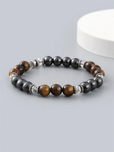 Tiger eye and hematite beaded bracelet for men with faceted glass on a grey background