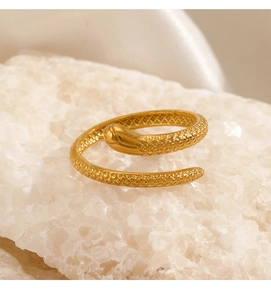 Detailed close-up of golden snake ring with scales texture on white mineral stone