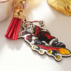 Cartoon Santa Claus on skateboard keychain with red tassel and golden metal clip