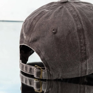 Détail de la boucle métallique réglable et du coton délavé vintage de la casquette