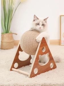 Detail of wooden cat scratcher ball showing a Ragdoll cat playing with sisal rope toy