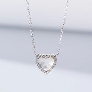 Macro shot of S925 silver heart necklace with white shell inlay and sparkling zirconia details