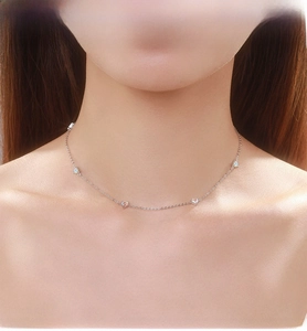 Close-up of S925 silver necklace with sparkling heart and star pendants on woman's neck