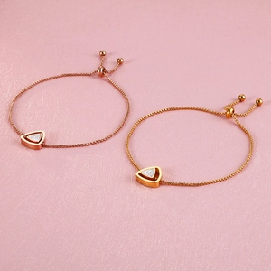 Détail de bracelets ajustables avec pendentif triangle en or rose et or