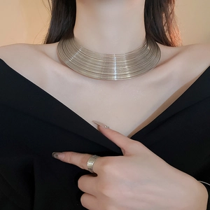 Macro shot of silver wide multi-layer geometric metal necklace set on neck