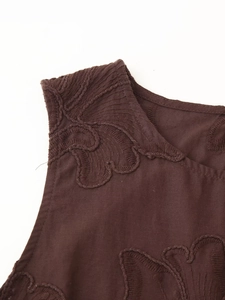 Détail du tissu de gilet brodé marron foncé montrant la texture et la broderie