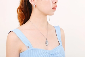 Close-up of model wearing silver geometric titanium steel necklace and earrings set