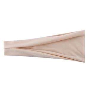 Close-up of peach elastic yoga headband showing fine ribbed knit fabric texture details