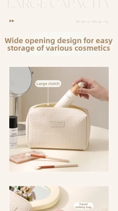 Close-up of cream woven PU leather cosmetic bag with dual zippers and travel accessories