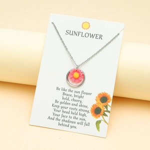 Silver sunflower pendant necklace with pink petals on a poetic white card and beige base