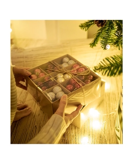 Close-up of a festive Christmas ball gift box with matte and glitter finishes in a cozy setting