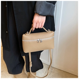 Detail of beige lychee pattern leather handbag with silver zipper and sturdy top handle