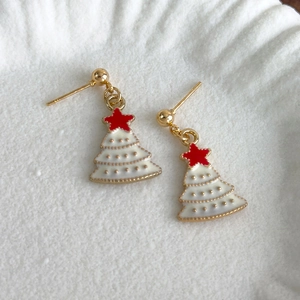 Detailed view of Christmas tree earrings with white enamel and golden base