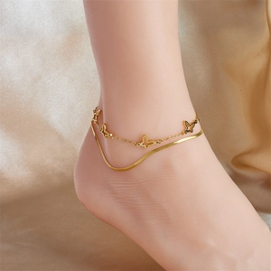 Close-up of golden double-layered anklet featuring hollow butterfly charms and snake chain