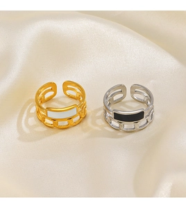 Detail of adjustable chain rings in gold and silver with black and white enamel inlays