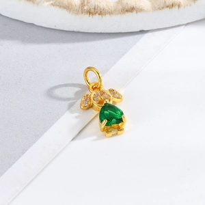 Detail shot of a gold figure pendant featuring a pear-cut green emerald and cubic zirconia