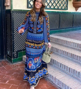 Detailed pattern of a long-sleeved floral dress with blue and orange ethnic motifs