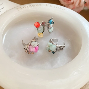 Macro shot of three-piece vintage rings set with colorful stones on white ceramic tray