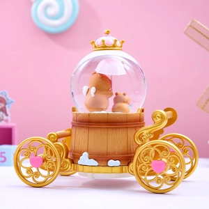 Detail of capybara carriage snow globe with bear figurines and golden crown top