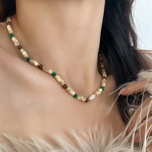 Detail of bohemian colorful beaded necklace featuring natural stones and freshwater pearls