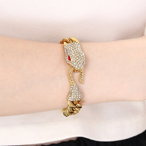 Detailed view of a gold-plated snake head Cuban bracelet with red gemstone eyes and diamonds