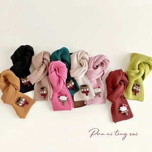 Close-up of colorful knitted children scarves featuring cute cartoon bear decorations