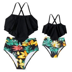 Matching mother daughter tankini sets with black ruffle tops and tropical print high waist bottoms