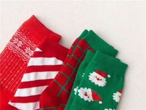 Detail of four festive Christmas cotton socks featuring Santa and Nordic snowflake patterns