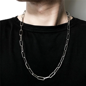 Dettaglio della spessa collana a catena argentata su un modello con t-shirt nera