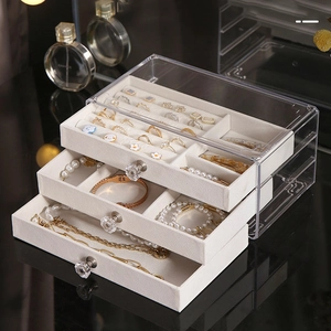 Three-layer clear acrylic jewelry box with beige velvet lining and crystal knobs