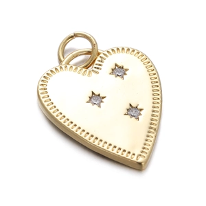Detailed view of a gold heart pendant with three star-shaped zircon stones on white background
