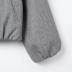 Detailed view of elastic cuffs and pocket on a grey wool blend bomber jacket
