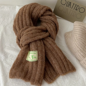 Macro detail of thick coffee brown wool knit scarf texture with luxury brand labels
