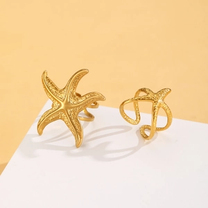 Detailed view of gold starfish open rings with textured metal surface on a minimalist stand
