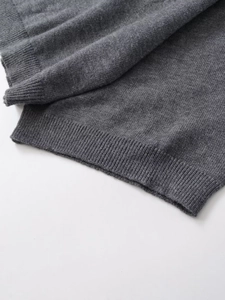 Close-up of tight ribbed knit texture and premium fiber on grey stand collar sweater