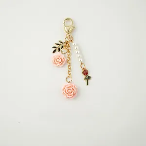 Detail of floral keychain with resin pink roses, gold heart clasp and pearl beads