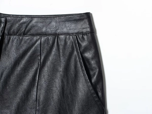 Close-up of black faux leather shorts with lychee texture and detailed stitching