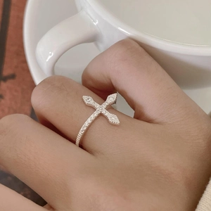 Detailed view of sterling silver cross ring with pavé set white zircon stones on hand