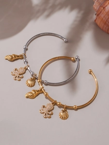 Detailed view of gold and silver ocean bangles with shell and octopus charms