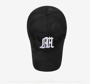 Detailed top view of a camouflage baseball cap with white gothic embroidery and mesh