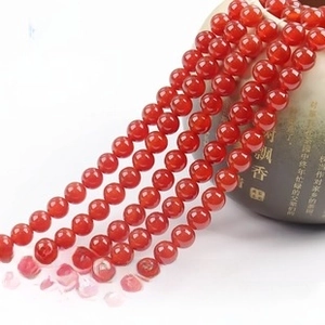 Close-up of polished red agate round beads strand with glossy finish for DIY jewelry