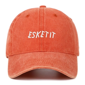 Close-up of white ESKETIT letter embroidery on a washed orange cotton baseball cap