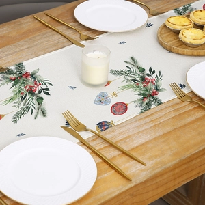 Christmas table runner with pine branches and colorful ornaments on rustic wood table