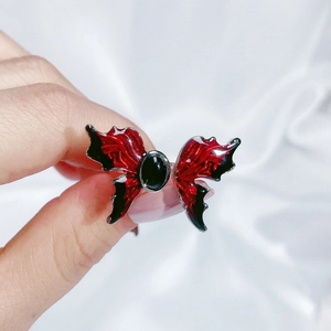 Detailed close-up of butterfly ring featuring red and black enamel with a black gemstone