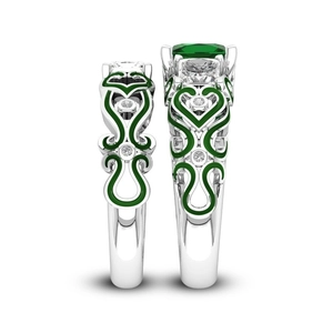 Detail van zilveren ringen met groene smaragd geslepen stenen en hart-emaille