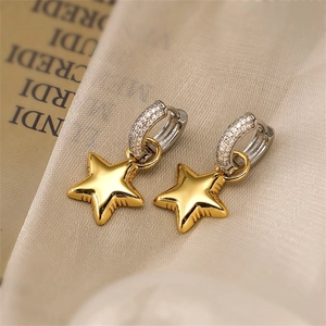 Close-up of gold star pendant earrings with silver rhinestone-encrusted hoop buckles