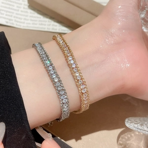 Detailed close-up of gold and silver plated chain bracelets with shimmering zircon stones
