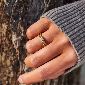 Gros plan sur une bague noeud en argent s925 doré avec incrustations de zircons brillants