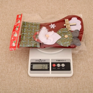 Linen Christmas stocking with Santa patch and wooden sign shown on a digital scale