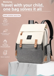 Detail of grey and white diaper bag with insulated bottle pocket on marble surface